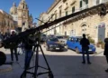 Gru cinematografica e troupe in piazza a Ragusa Ibla, davanti al Duomo di San Giorgio, tra auto parcheggiate