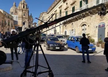 Gru cinematografica e troupe in piazza a Ragusa Ibla, davanti al Duomo di San Giorgio, tra auto parcheggiate