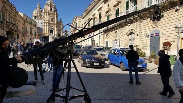 Gru cinematografica e troupe in piazza a Ragusa Ibla, davanti al Duomo di San Giorgio, tra auto parcheggiate