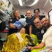 Operatori del 118 in ambulanza con la neomamma in coperta termica, il compagno e il neonato in braccio a un'operatrice.