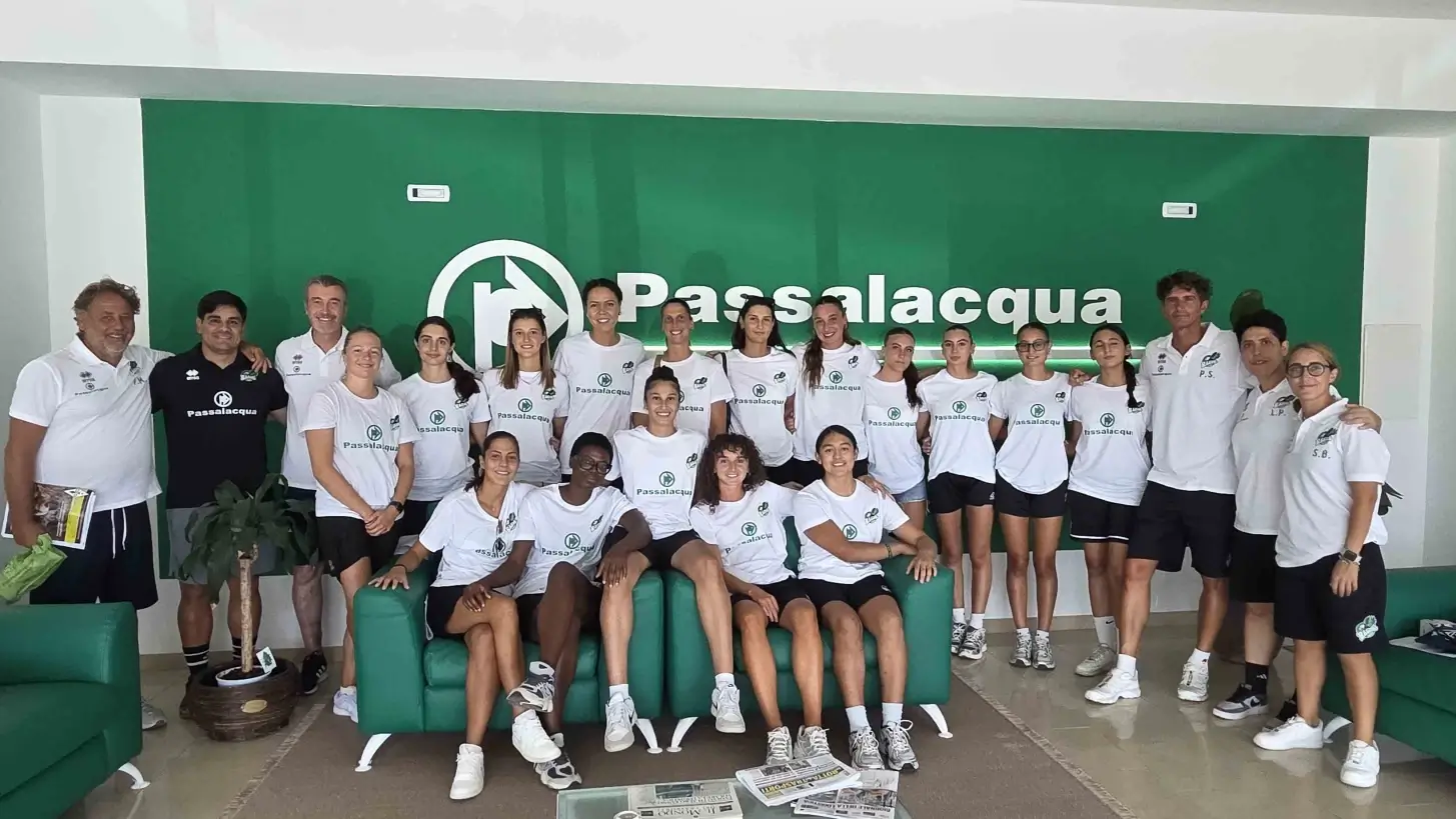 Giocatrici e staff della Passalacqua Ragusa Basket in maglia bianca posano nella sede del main sponsor a Ragusa