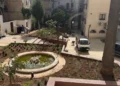 Vista dall'alto di piazzetta Mons. Tidona a Ragusa con la nuova vasca, le aiuole piantumate e operai al lavoro