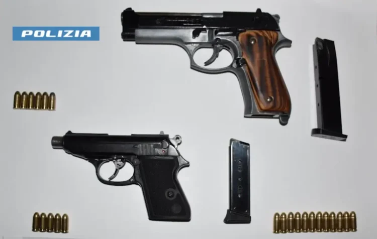 Due pistole sequestrate con caricatori e munizioni su sfondo bianco, foto della Polizia di Stato
