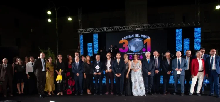 Foto di gruppo sul palco in piazza Libertà a Ragusa, premiati e autorità davanti al maxischermo del Premio
