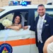 Sposi in posa accanto a un mezzo della Protezione Civile: la sposa al finestrino con bouquet, lo sposo in abito blu.