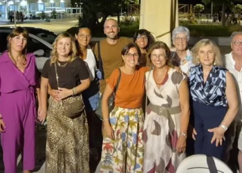 Gruppo di ex studenti e insegnanti in posa di sera davanti a un locale di Marina di Modica