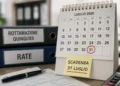 Calendario da tavolo con il 31 luglio cerchiato in rosso, cartellino giallo con scritta "Scadenza 31 luglio" e raccoglitori etichettati "Rottamazione quinquies" e "Rate"