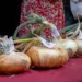 Cipolle di Giarratana a bulbo piatto allineate su un tavolo con tovaglia rossa durante la sagra, con cartellini identificativi dei produttori.