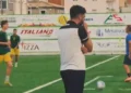 Un allenatore osserva il campo durante il test Santa Croce Soccer-Niscemi, giocatori in maglia verde-gialla sullo sfondo