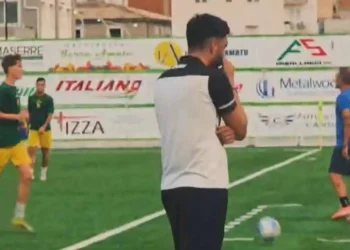 Un allenatore osserva il campo durante il test Santa Croce Soccer-Niscemi, giocatori in maglia verde-gialla sullo sfondo