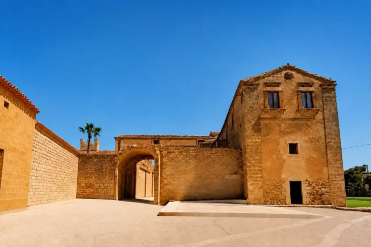Eremo delle Milizie a Scicli, con cortile, arco in pietra e antichi edifici in muratura