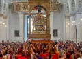 Portatori sollevano il simulacro di San Bartolomeo durante la Scinnuta, davanti ai fedeli nella chiesa di Giarratana.