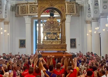 Portatori sollevano il simulacro di San Bartolomeo durante la Scinnuta, davanti ai fedeli nella chiesa di Giarratana.