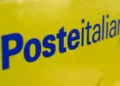 Cartello giallo con logo Poste Italiane scritto in blu, primo piano su segnaletica o pannello identificativo di un ufficio postale