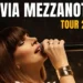 Cantante con microfono in primo piano durante un’esibizione, con la scritta “Silvia Mezzanotte Tour 2026”.