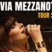 Silvia Mezzanotte canta al microfono durante un concerto, con la grafica del Tour 2026 in sovrimpressione