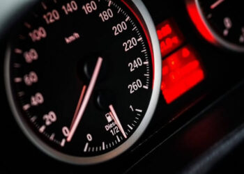 Primo piano del tachimetro di un'auto con spie rosse accese sul cruscotto