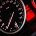 Primo piano del tachimetro di un'auto con spie rosse accese sul cruscotto