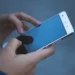 Mano che tiene uno smartphone con schermo spento durante un disservizio della rete mobile