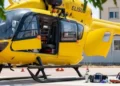 Elicottero giallo del servizio di elisoccorso a terra, portello aperto