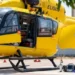 Elicottero giallo del servizio di elisoccorso a terra, portello aperto