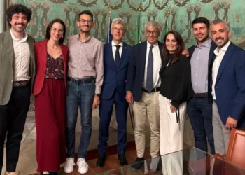 Delegazione di giovani e rappresentanti istituzionali in una sala comunale