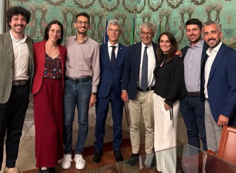 Delegazione di giovani e rappresentanti istituzionali in una sala comunale