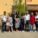 Gruppo di persone davanti a una villetta dell'ex base Nato di Comiso, edificio con intonaco degradato sullo sfondo