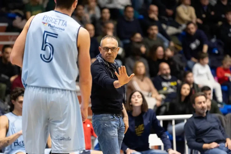 Coach Gianni Recupido impartisce istruzioni a un giocatore della Virtus Ragusa durante una partita al palazzetto