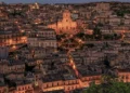 Veduta notturna del centro storico di Modica con il Duomo di San Giorgio illuminato tra le case.