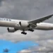 Aereo United Airlines in fase di atterraggio con carrello abbassato, cielo nuvoloso sullo sfondo