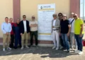 Gruppo di persone davanti al cartello di cantiere del Comune di Comiso per la riqualificazione della zona artigianale