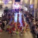Ballerini in costume colorato si esibiscono tra la folla in una via illuminata di Chiaramonte Gulfi durante Zuppà.