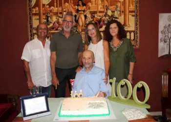 Giuseppe festeggia 100 anni a Ragusa davanti alla torta con il numero 100, insieme ad alcuni familiari