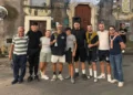 Cinque uomini in maglia azzurra con una coppa dopo il torneo di calcio balilla umano a Monterosso Almo