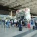 Passeggeri con trolley in fila ai banchi check-in 16-20 nel terminal dell'aeroporto di Catania