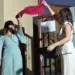 Lorena e Giusi tagliano un nastro rosso davanti all'ingresso decorato con il logo a forma di albero colorato
