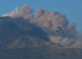 Nube di cenere si leva dal cratere sommitale dell'Etna, cielo sereno sullo sfondo