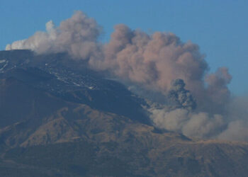 Nube di cenere si leva dal cratere sommitale dell'Etna, cielo sereno sullo sfondo