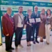 Premiazione dell'ASP di Ragusa a Best InSanitas: sei persone con due targhe davanti al pannello dell'evento