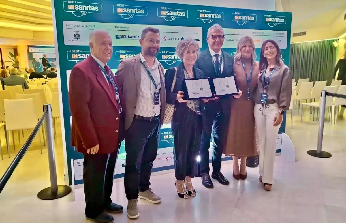 Premiazione dell'ASP di Ragusa a Best InSanitas: sei persone con due targhe davanti al pannello dell'evento