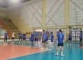 Giocatori dell'Avimec Modica in maglia blu durante un allenamento in palestra, uno palleggia al centro del campo