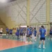 Giocatori dell'Avimec Modica in maglia blu durante un allenamento in palestra, uno palleggia al centro del campo