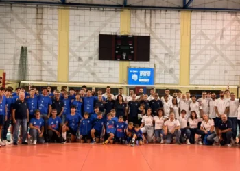 Foto di gruppo dell'Avimec Modica al PalaRizza: atleti in maglia blu, staff in polo bianca, giovanissimi seduti in prima fila