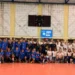 Foto di gruppo dell'Avimec Modica al PalaRizza: atleti in maglia blu, staff in polo bianca, giovanissimi seduti in prima fila