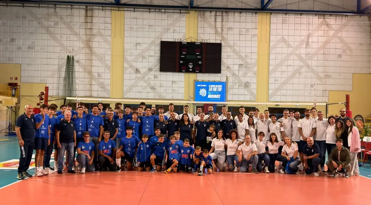 Foto di gruppo dell'Avimec Modica al PalaRizza: atleti in maglia blu, staff in polo bianca, giovanissimi seduti in prima fila