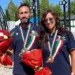 Due atleti di bocce Scicli con medaglie e mazzi di fiori durante la premiazione