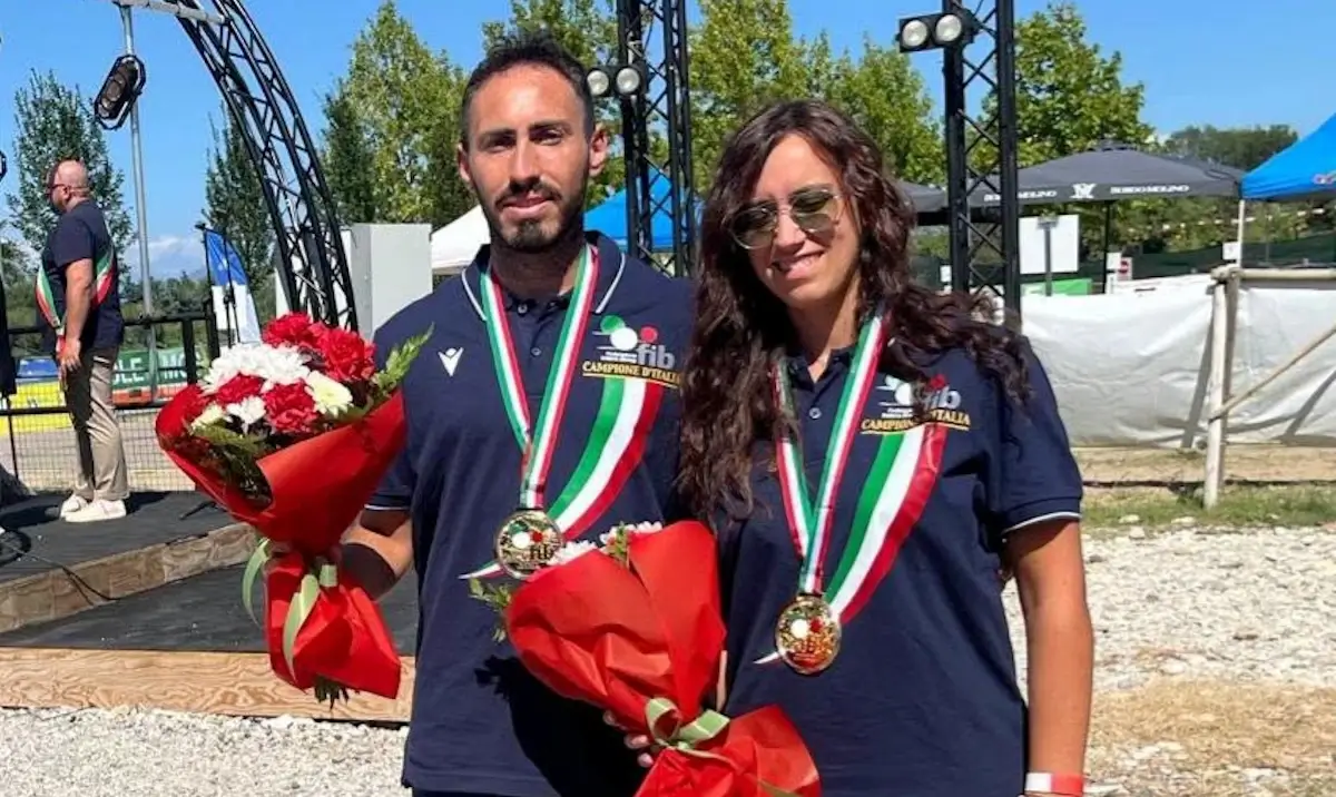 Due atleti di bocce Scicli con medaglie e mazzi di fiori durante la premiazione