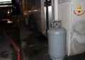 Bombole di GPL lungo il muro di un edificio di notte