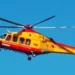 Elicottero del servizio di elisoccorso 118, giallo e rosso, in volo contro un cielo azzurro